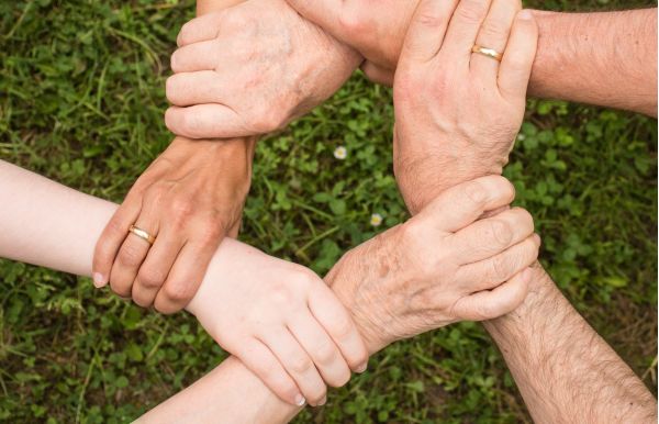 Verschillende mensen van diverse leeftijden die elkaar vastpakken. Samenwerking.