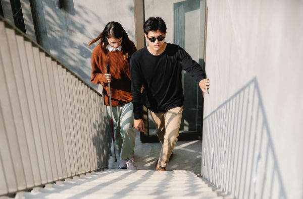 blinde man met begeleider