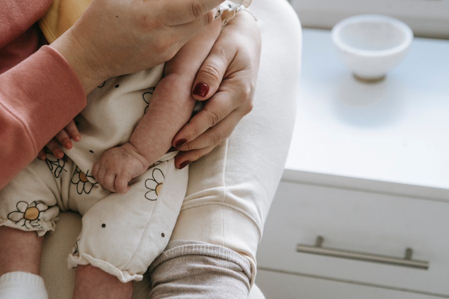 Vrouw houdt baby vast in haar hand