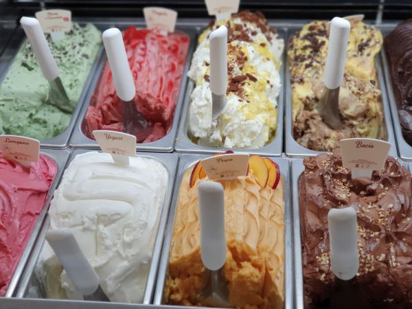 Afbeelding van bakken met schepijs, met opscheplepels er in