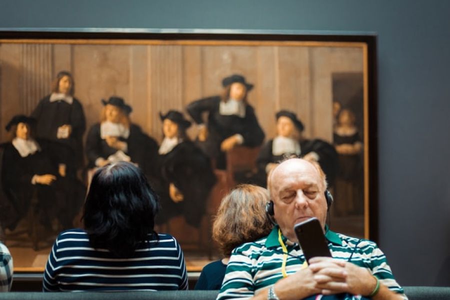 man met koptelefoon in rijksmuseum