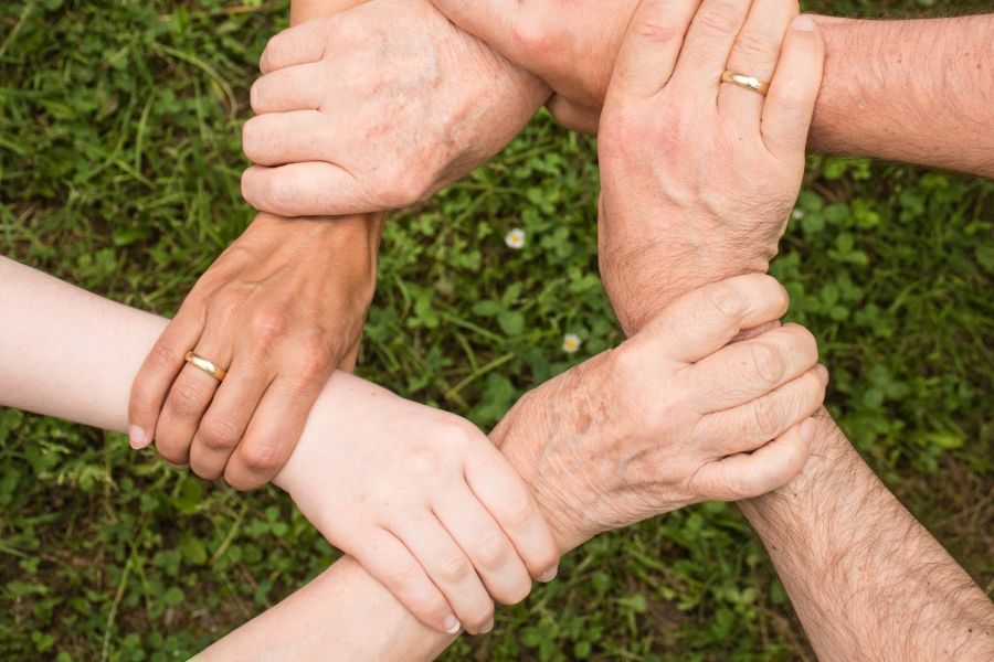 Verschillende mensen van diverse leeftijden die elkaar vastpakken. Samenwerking.
