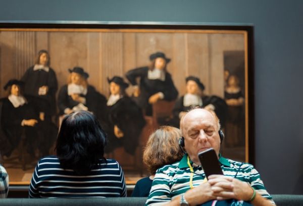 man met koptelefoon in rijksmuseum